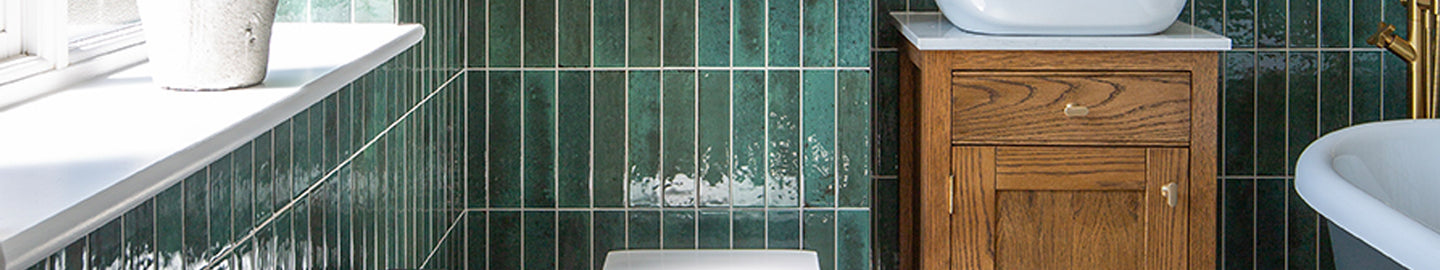 bathroom with green metro tiles and toilet with vanity sink 