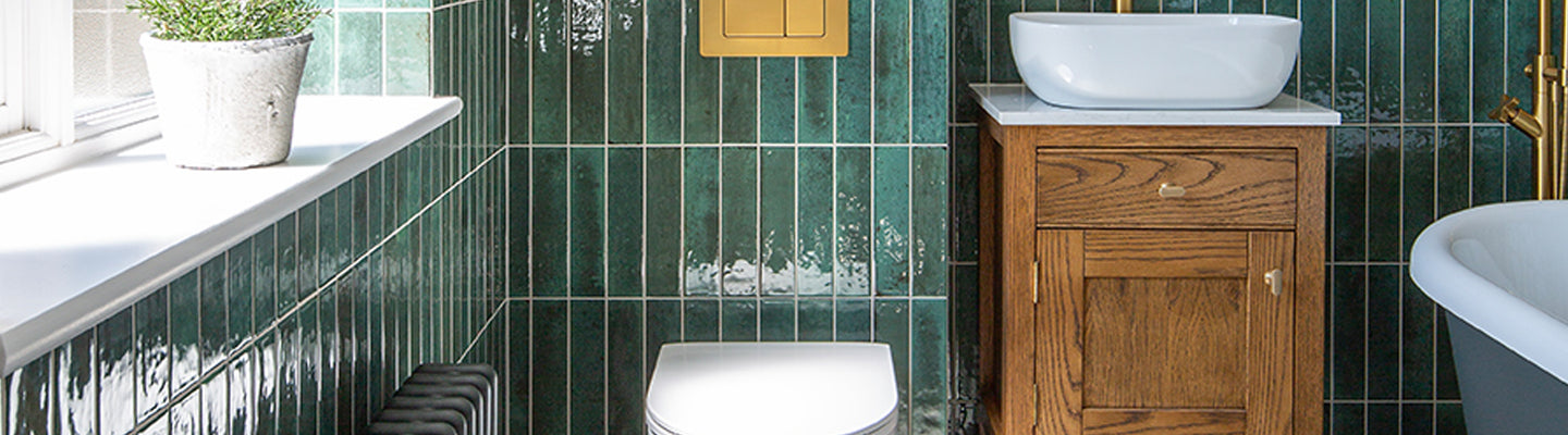 bathroom with green metro tiles and toilet with vanity sink 