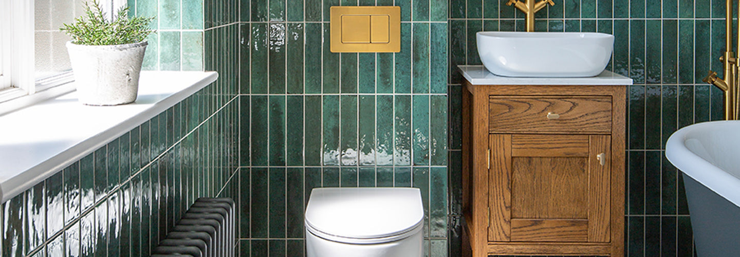 bathroom with green metro tiles and toilet with vanity sink 