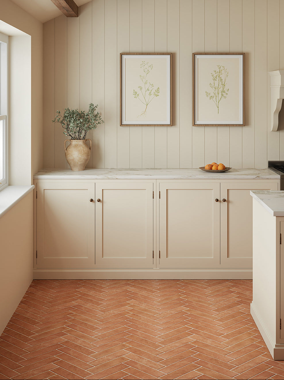 A shot of Quorn Stone's Cottura Terracotta Tiles being used as the flooring in a kitchen with an island table.