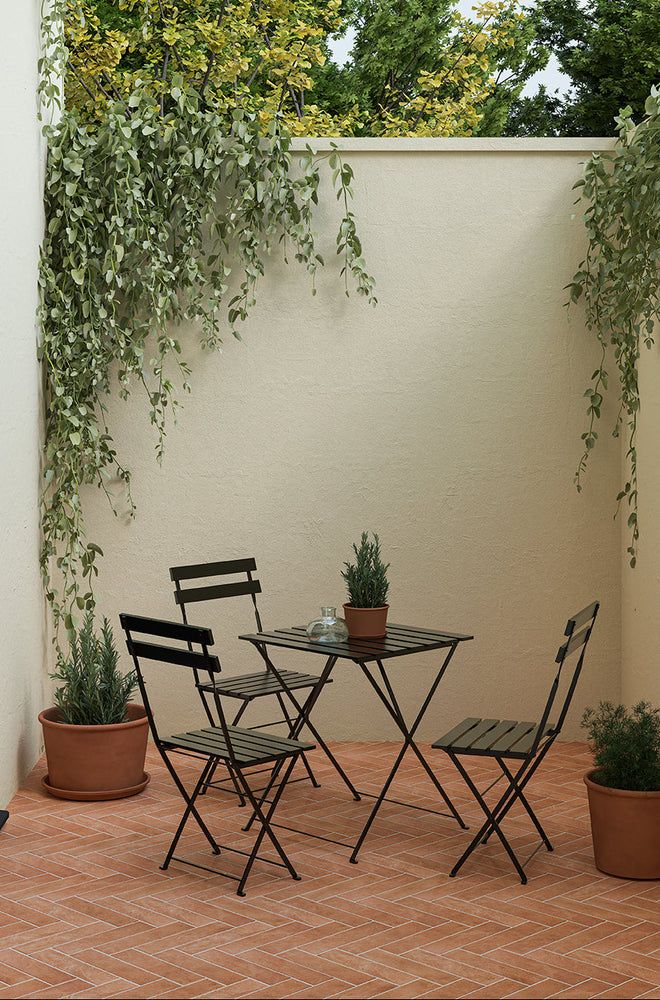 A shot of Quorn Stone's Cottura Terracotta Tiles being used as the flooring in a courtyard with a bistro table and chair set.